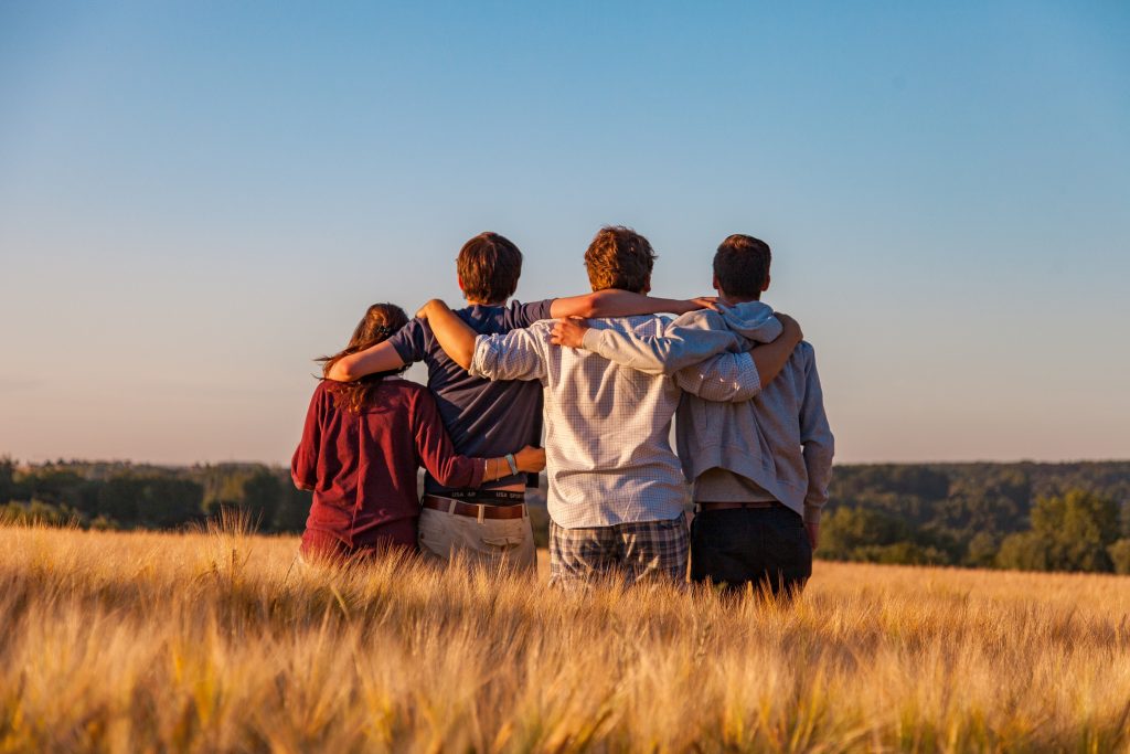 Group of friends support themselves over a nice vista