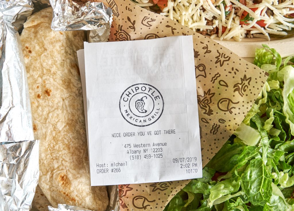 Chipotle plate with burritos and salad with receipt.