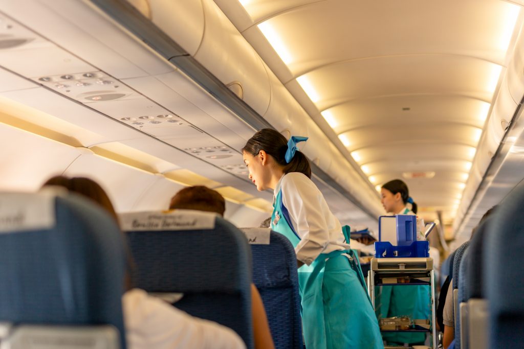 Bangkok Airways flight attendant serve food and drinks to passengers on board.